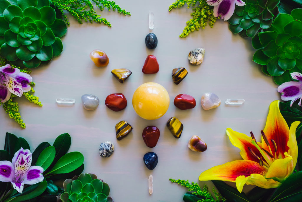 Crystal Grid on Grey Table with Red Jasper, Mixed Agate, Quartz, Tiger's Eye and Aventurine with Summer Botanicals