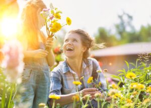 women and child smiling in garden. Connotes growth.