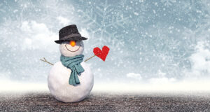 Snowman with a jaunty bowler hat holding a red heart.